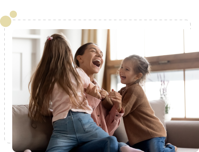 Three young girls are laughing and playing together.